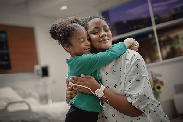 patient with Masimo sensor hugging child